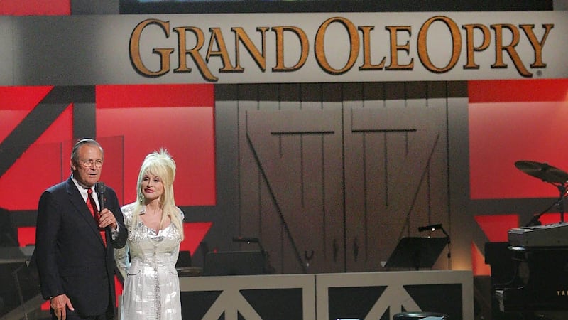 Secretary of Defense Donald Rumsfeld takes the stage with host Dolly Parton at the Grand Ole...
