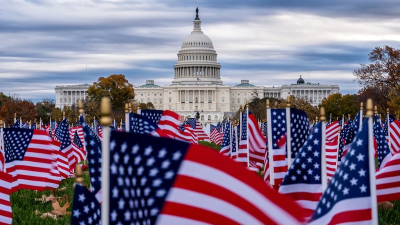 Miniature American flags flutter in wind gusts across the National Mall near the Capitol in...