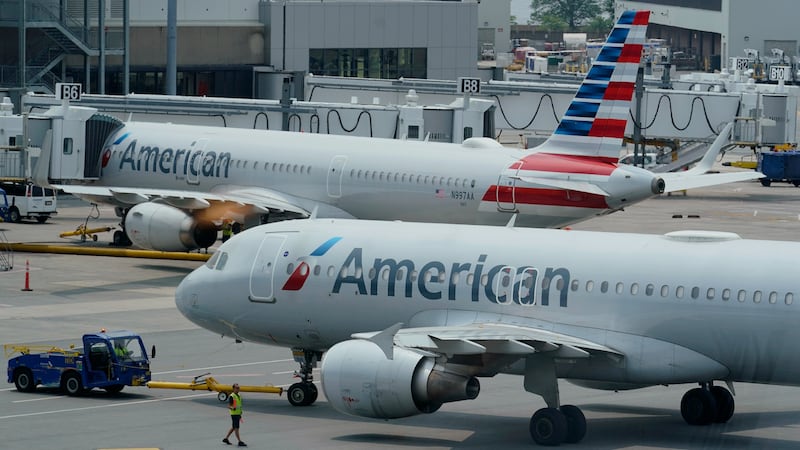 FILE - American Airlines passenger jets prepare for departure near a terminal at Boston Logan...